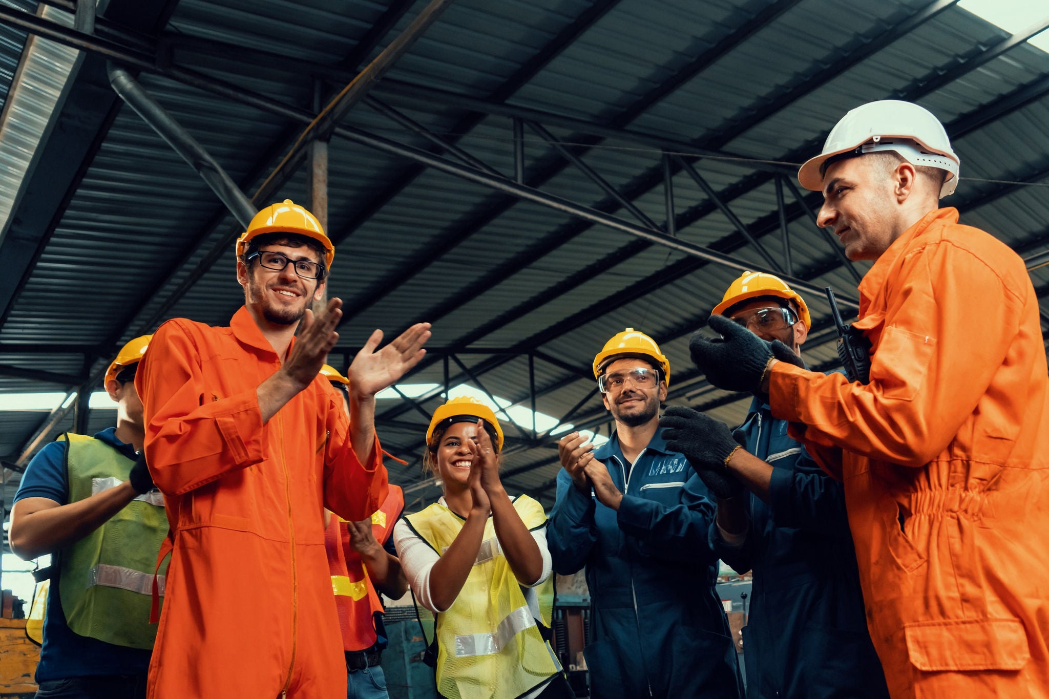 Diverse team of factory workers and engineers collaborating in a modern plant